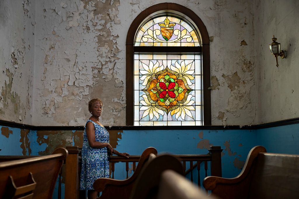 Third place, Portrait Personality - Joseph Scheller / Ohio University, "Zion Baptist"Doctor Tee Ford-Ahmed, director of communications for the Mount Zion Baptist Church Preservation Society, poses for a portrait inside of the historic church next to the stain-glass window that has since become the symbol for the organization, in Athens, Ohio, on July 21, 2021.