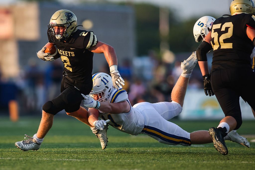 First place, Ron Kuntz Sports Photographer of the Year - Rebecca Benson / The BladePerrysburg’s Connor Walendzak (left) runs with the ball as Findlay’s Connor Harp tries to bring him down during a game at Steinecker Stadium in Perrysburg on August 27, 2021. 