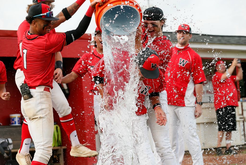 Second place, Ron Kuntz Sports Photographer of the Year - Adam Cairns / The Columbus DispatchWesterville South head coach Tim Bates gets a bucket of water dumped on his head following the Wildcats' 3-2 win over Hilliard Darby in the Div. I district final at Westerville South on May 26, 2021. 