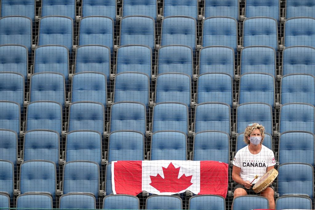 Second place, Sports Picture Story - Kareem Elgazzar / The Cincinnati Enquirer, “Olympic Softball”A member of Team Canada staff supports the team in the fourth inning during an opening-round game against Canada in the Tokyo 2020 Olympic Summer Games, July 26, 2021 at Yokohama Baseball Stadium in Yokohama, Japan. Fans were not permitted to watch the games due to the coronavirus pandemic.