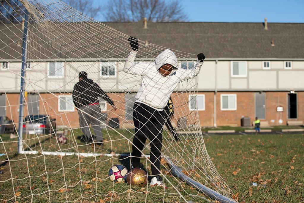 Third place, Sports Picture Story - Adam Cairns / The Columbus Dispatch, “Hilltop Tigers Soccer Program”Christian McNair, 10, retrieves soccer balls from the goal at Havenwood Townhomes in the Hilltop on Nov. 22. Soccer is a popular hobby for many of the kids in the Hilltop like Christian. My Project USA funds the Hilltop Tigers program to keep kids active and out of trouble year round.