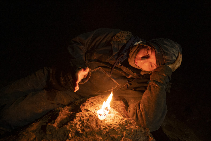 Student Photographer of the Year - Second Place, Joe Timmerman / Ohio UniversityHolly McClintock lays alongside a burning wax candle for warmth while taking a break from surveying in Roppel Cave. 
