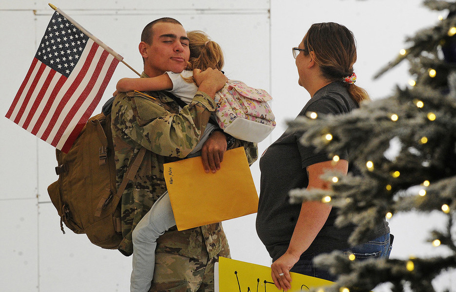 Feature - Second Place, “Coming Home”Eight year old Ella Grace Rike hugs her brother Riley Allen after being away for 6 months in the military. Allens mother Anta Rike (right) welcomed him home for Christmas at the Dayton International Airport.  (Marshall Gorby / Dayton Daily News)