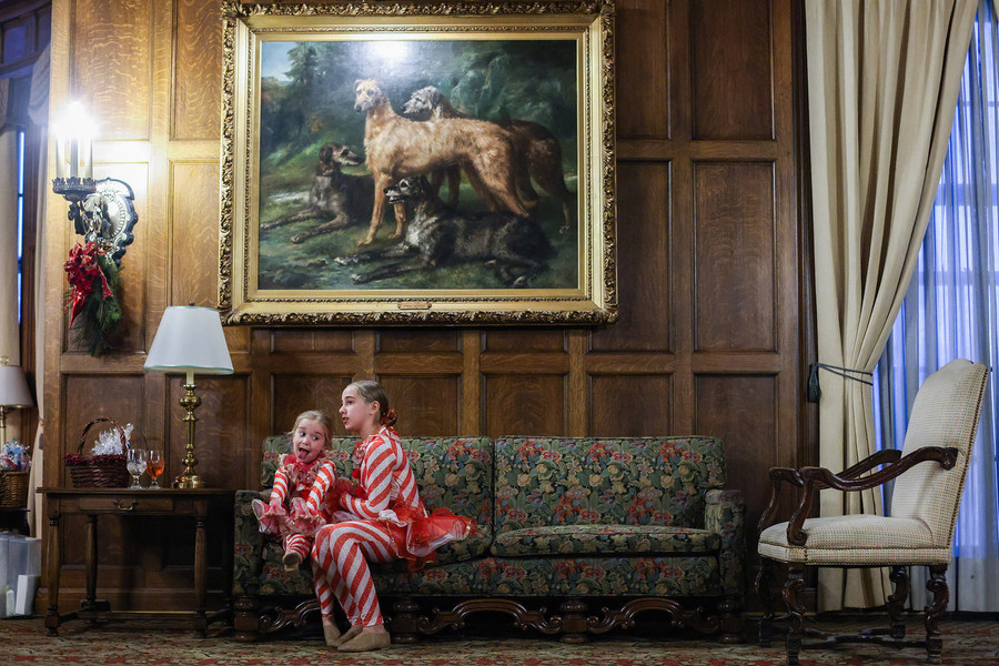Feature - Third Place, “Santa’s Helpers”Alessa Hirschfeld, 5, sits on a couch with her sister Adelle, 12, as they wait to help hand out goodie bags for kids visiting Santa during the Toledo Club’s Tea Dance. (Rebecca Benson / The Blade)
