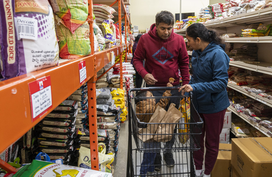 Feature Picture Story - First Place, “Telugu Americans”Pavan Vemuri, 37, and Keerthi Sanivarapu, 35, along with their son Ridhay Vemuri, 2, shop at the Pandey Indian store for monthly groceries. “Raising a kid with dual identity, we are not the first people to come to the US and experiment with it. Many people have already done it and it is our turn right now in our life. It is not easy. We are trying our way let us see how successful we get at it.” says Keerthi.    (Akash Pamarthy / Ohio University)