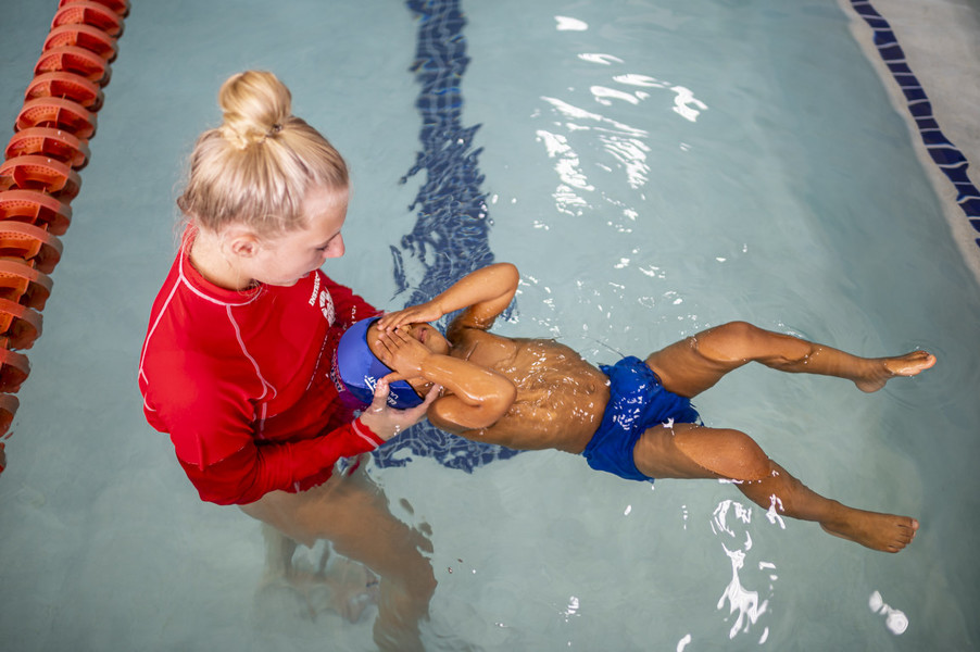 Feature Picture Story - First Place, “Telugu Americans”Ridhay Vemuri, 2, closes his eyes as his swim instructor Kylie Modreski, 15, holds him during his swimming class at the British swimming school. According to Ridhay’s parents, once he is at a conscious age to make his own decisions, they want him to embrace both the cultures and respect them. When he is outside of home, he is exposed to American culture but at home it is going to stay Indian.  (Akash Pamarthy / Ohio University)
