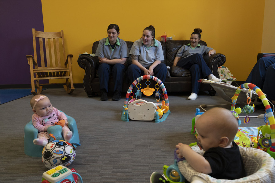 Feature Picture Story - Second Place, “ABCs Nursery Program”Shaina Alloway (left) Reese Reed and Morgan Brodt laugh while watching their babies play inside of the Hope House where residents in the ABCs program at the Ohio Reformatory for Women live, in Marysville.  “We’re all in prison here, we all struggle, but raising a child here is a whole different struggle that people wouldn’t understand if they hadn’t been there,” Brodt said. “And to have that with each other, it’s a bond like you wouldn’t… Like we’re learning, we’re learning to not just be parents, but parents in prison and we’re doing it together.”   (Joseph Scheller / Ohio University)