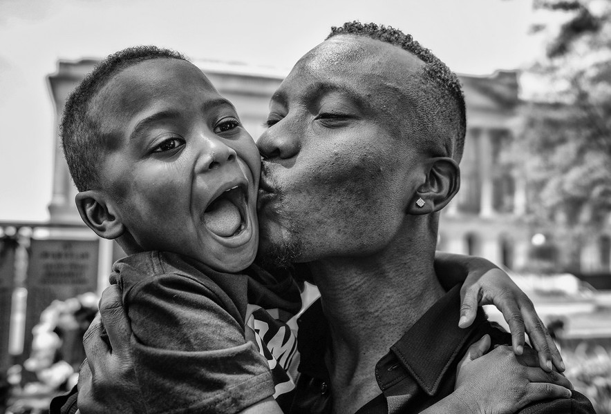 Feature Picture Story - Third Place, “Naturalization Ceremony”Olatunji Muyideen Yusuff, originally from Nigeria, kisses his son Wareez, 4, after becoming a US citizen during a Naturalization Ceremony at the Civic Center Mall in Toledo. (Jeremy Wadsworth / The Blade)