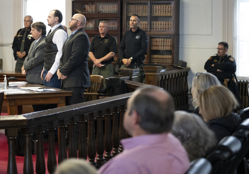 News Picture Story - First Place, “Wagner Trial”George Wagner IV (center) stands next to attorneys John P. Parker and Richard M. Nash while he receives his sentence from Judge Randy Deering, Members of the Rhoden family sit in the foreground. Wagner was found guilty on 22 counts and sentenced to life without parole for his role in the 2016 Pike County massacre. Wagner was indicted on 22 counts including eight counts of aggravated murder.  (Brooke LaValley / The Columbus Dispatch)