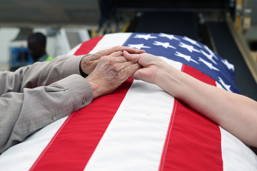 News Picture Story - Second Place, “Korean War Vet”David Lilley, of Westerville, and Roberta Fagan, of Westerville, hold hands over the remains of David's brother, Korean War Army veteran private first class Jack E. Lilley, after his arrival from an American Airlines flight from Honolulu on June 10, 2022, at John Glenn Columbus International Airport. Pfc. Lilley was killed during the war on July 20, 1950 and was reported missing in action before his remains were identified Nov. 5, 2021.  (Shane Flanigan / ThisWeek Community News)