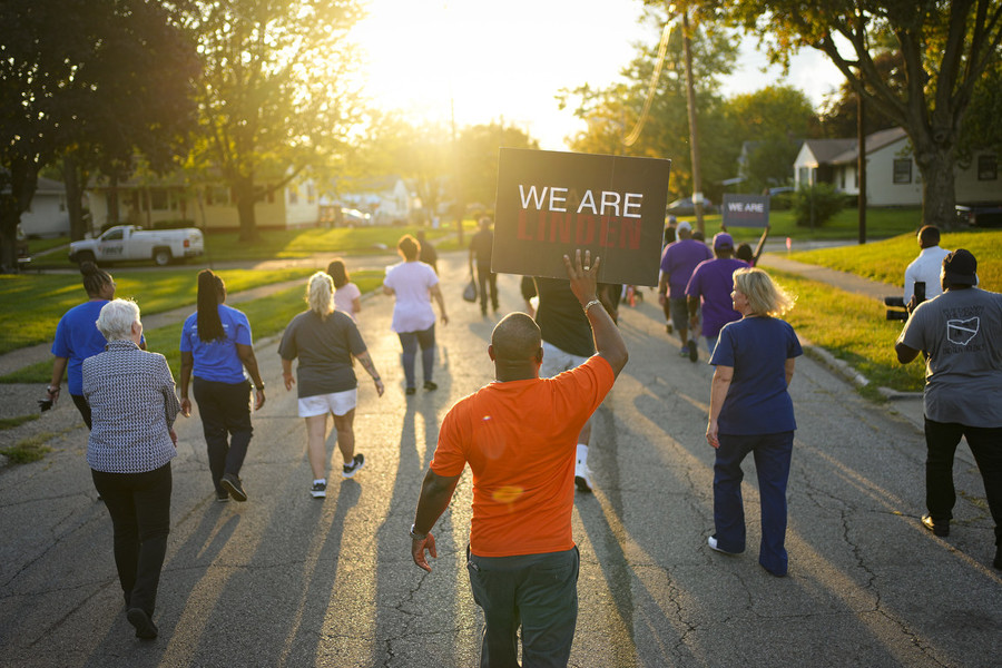 Photographer of the Year - Large Market - First Place, Adam Cairns / The Columbus DispatchDana Brock carries a "We Are Linden" sign as Linden Community & Columbus Ohio Stop The Violence walk a neighborhood behind the Northern Lights shopping center shouting messages about stopping gun violence and bringing the Linden community together on Sept. 19. The group passed out informational packets from local organizations and shouted messages about stopping gun violence and bringing the Linden community together.  