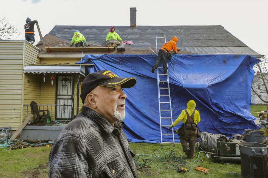 Photographer of the Year - Large Market - Second Place, Jeremy Wadsworth / The BladeVeteran Glenn Walker stood in his front yard and watched as a roofing crew layered rows of new brown asphalt shingles on top of his 124-year-old North Toledo home."I'm feeling good, I'm feeling good," said Mr. Walker, 69, the remnants of the old roof strewn around him. "You know how long it's taken me to get this. ... It's a blessing." Mr. Walker and his wife, Sheila, struggled a long time to figure out how to get a new roof. They dreaded big rainstorms, which would often trigger multiple leaks inside their small yellow home on St. John Avenue. Mr. Walker got his new roof installed with aid of the Lucas County Veterans Service Commission in Toledo.  