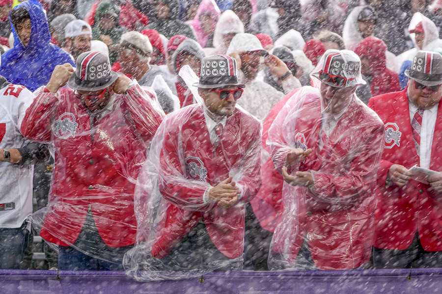 Ron Kuntz Sports Photographer of the Year - First Place Ohio State Buckeyes fans stand in the blowing rain during the first half of the NCAA football game against the Northwestern Wildcats at Ryan Field in Evanston, Ill.  (Adam Cairns / The Columbus Dispatch)