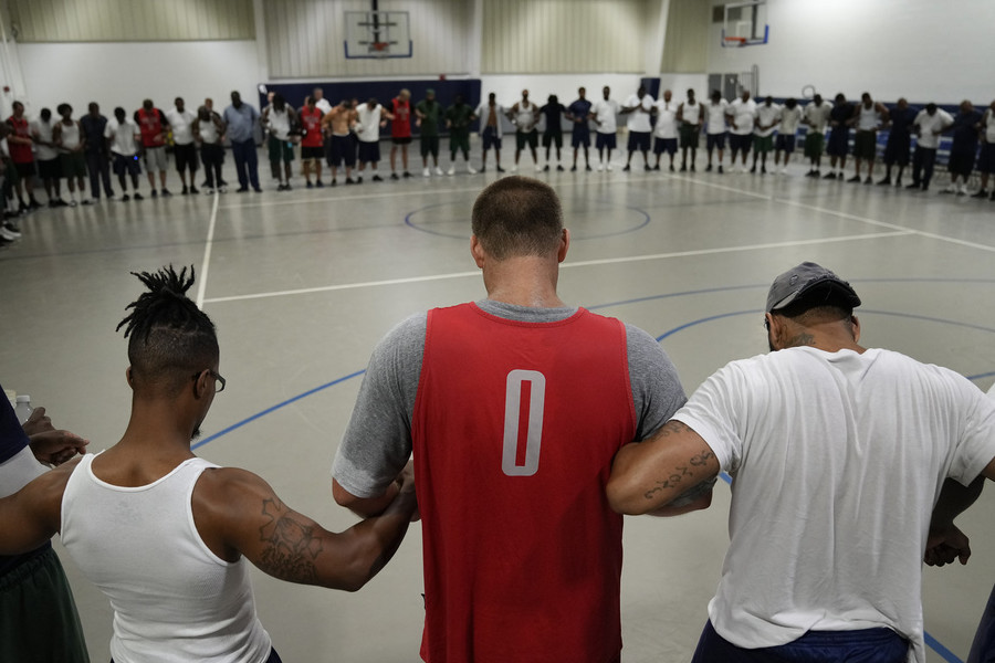 Ron Kuntz Sports Photographer of the Year - First Place For a moment of prayer, Luke Kraus joins arms in prayer with residents at the Richland Correctional Institution following a basketball game between residents and a group of "outsiders" that also included former Ohio State star Aaron Craft. As part of the Faithful In Serving Together prison ministry program, basketball, along with dialogue and religion, is used to help the incarcerated population find common ground.   (Adam Cairns / The Columbus Dispatch)
