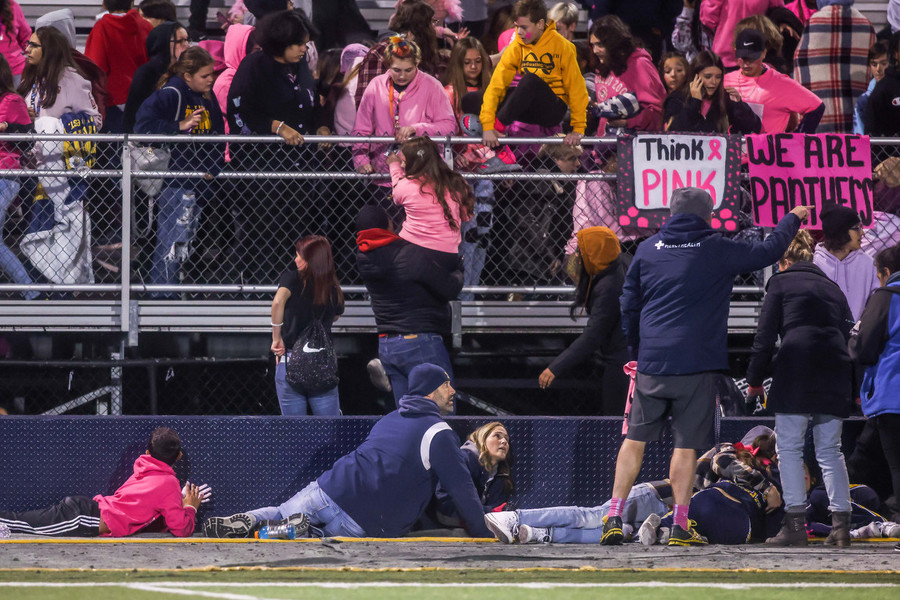 Ron Kuntz Sports Photographer of the Year - Second Place Chaos ensues as students attempt to flee the stands and others hide behind cheerleading blocks after reported gunshots fired during a Three Rivers Athletic Conference football game against the Whitmer Panthers and Central Catholic Fighting Irish at Whitmer High School in Toledo.   (Isaac Ritchey / The Blade)
