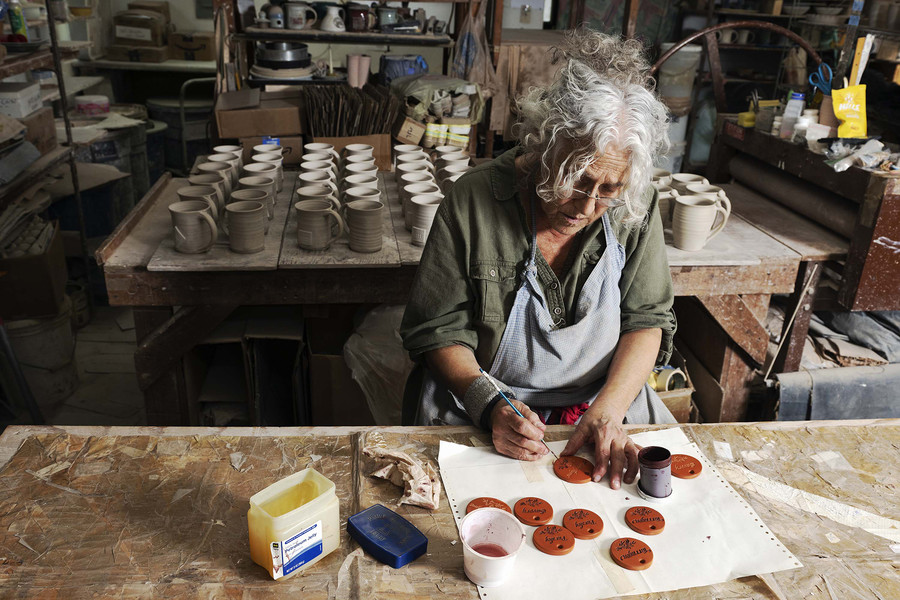 1st - Chuck Scott Student Photographer of the Year Susan "Susie" Rhea Abramovitz, 72, of Youngstown, Ohio paints extra terracotta garden markers while working to fulfill an order at her studio Rock Riffle Run Pottery in the unincorporated community of Shade, Ohio, on Monday, November 20, 2023.  (Loriene Perera / Ohio University)