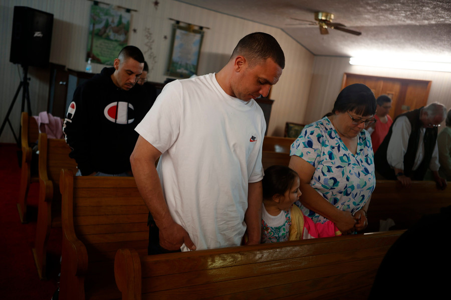 Feature Picture Story - 2nd, “See You When I See You”Zach Singer prays alongside his daughter Riya Belle and his mother Jennie Singer at Pastor Junior Walker’s Church in Chester Hill.  (Michael Blackshire / Ohio University)