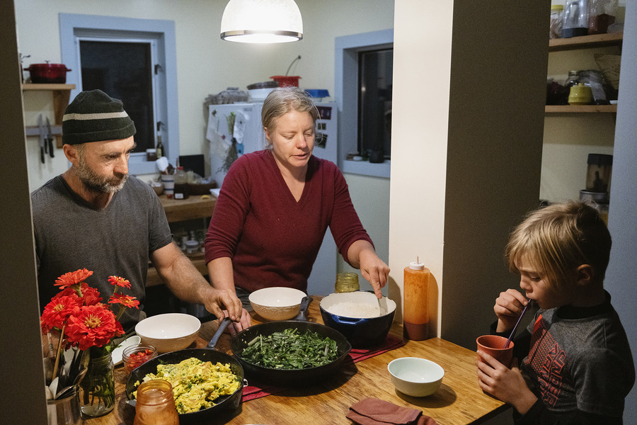 Feature Picture Story - 3rd, “Symphony of Soil”Seed farmer Lindsay A. Klaunig, 39, of Toledo and her partner Michael S. Barnes, 48, of Santa Fe, New Mexico remind their son Elias V. Barnes, 9, of Athens, to take a bath after he is done with his meal during dinnertime in their home at Trouvaille Farm in the unincorporated community of Shade, Ohio. According to Klaunig, her partner is primarily responsible for cooking for the household, and on most days dinner is their only meal of the day. "We try to make up for skipped meals during dinnertime. We try to make that a solid meal with you know, our own vegetables, our own food," Klaunig shared.  (Loriene Perera / Ohio University)