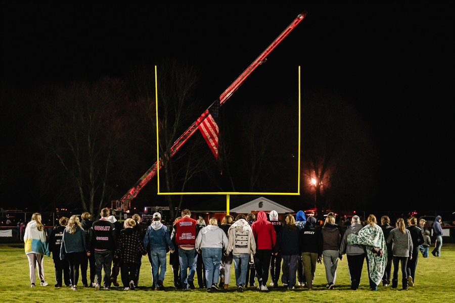 News Picture Story - 1st, “Tuscarawas Valley Bus Tragedy”Students walk the football field during the community prayer vigil, Tuesday, Nov. 14 at the Tuscarawas Valley Schools football stadium in Zoarville, Ohio. Most of the students pictured were on the bus that crashed earlier in the day on I-70 in Licking County, killing 6 people. (Andrew Dolph / The Times Reporter)