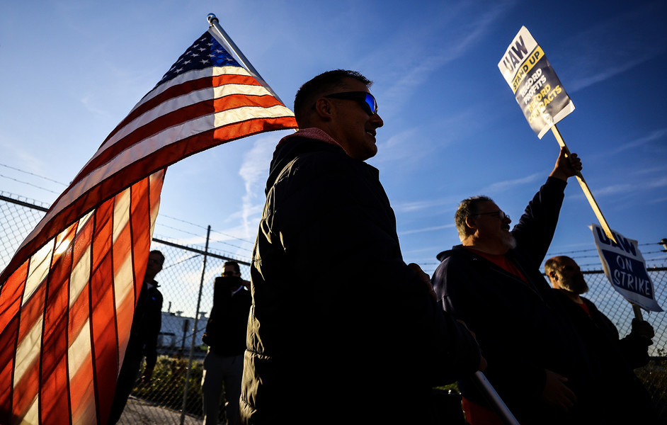 News Picture Story - 3rd, “UAW Strike”UAW members Dan Schlieman, with flag,  and Brad Geer work the picket line during day 5 of the strike Tuesday, September 19, 2023, at the Stellantis Toledo Assembly Complex where Jeeps are made in Toledo, Ohio.  (Jeremy Wadsworth / The Blade)