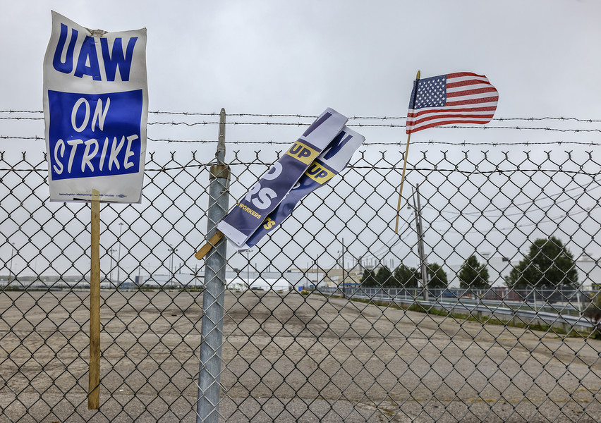 News Picture Story - 3rd, “UAW Strike”Signs and a flag adorn the fence as United Auto Workers continue their strike Monday, September 25, 2023, at the Stellantis Toledo Assembly Complex in Toledo. (Jeremy Wadsworth / The Blade)