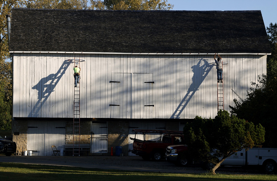 Pictorial - Award of Excellence, “Barn Shadows”Two workers from Enterprise Roofing cast their shadows on the side of the barn at George Rogers Clark Park as they install brackets to hold a new copper cutter on the barn Tuesday, Oct. 3, 2023.  (Bill Lackey / Springfield News-Sun)