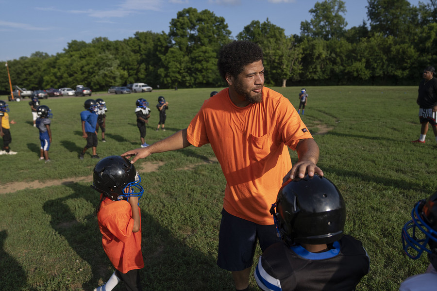 2nd - Photographer of the Year - Large Market Coach Drake Jones helps adjust helmets during football practice with Columbus ICE (Inspiring Children to Excellence) at Helsel Park on the East Side of Columbus. ICE offers direct outreach to kids who are living in areas of Columbus that experience the highest rates of gun violence.  (Brooke LaValley / The Columbus Dispatch)