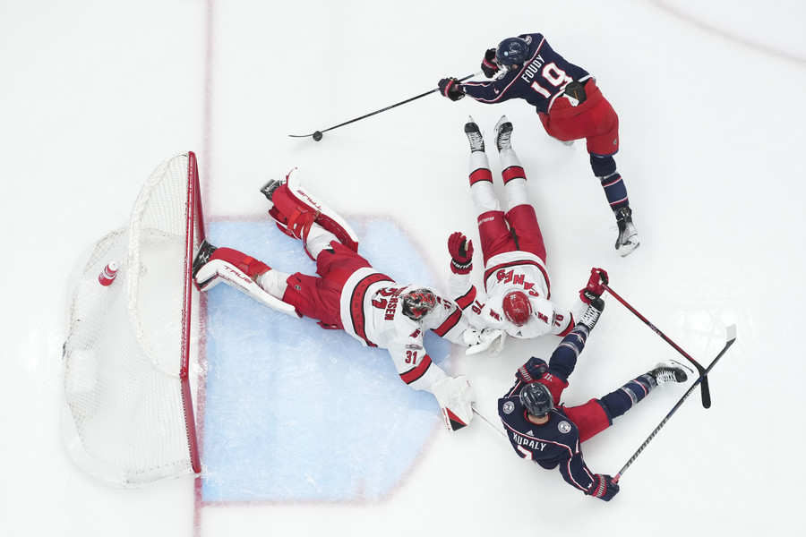 3rd - Photographer of the Year - Large Market Columbus Blue Jackets center Liam Foudy (19) tries to wrap a shot around Carolina Hurricanes goaltender Frederik Andersen (31), defenseman Brady Skjei (76) and center Sean Kuraly (7) during the second period of the NHL hockey game at Nationwide Arena. (Adam Cairns / The Columbus Dispatch)