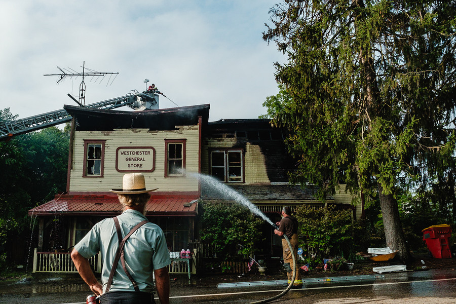 1st - Photographer of the Year - Small Market Freeport Volunteer Fire Department firefighter Charles Cyrus (right) puts additional water on the Westchester General Store after an overnight fire gutted the 119-year-old structure, Tuesday, July 25. Working in the Cadiz Volunteer Fire Department ladder truck's bucket (left) is firefighter, Kayl Carter. The fire was called in at 12:35 am after an apparent lightning strike that hit a window operated air condition unit, according to the owners. No injuries were reported. (Andrew Dolph / The Times Reporter)