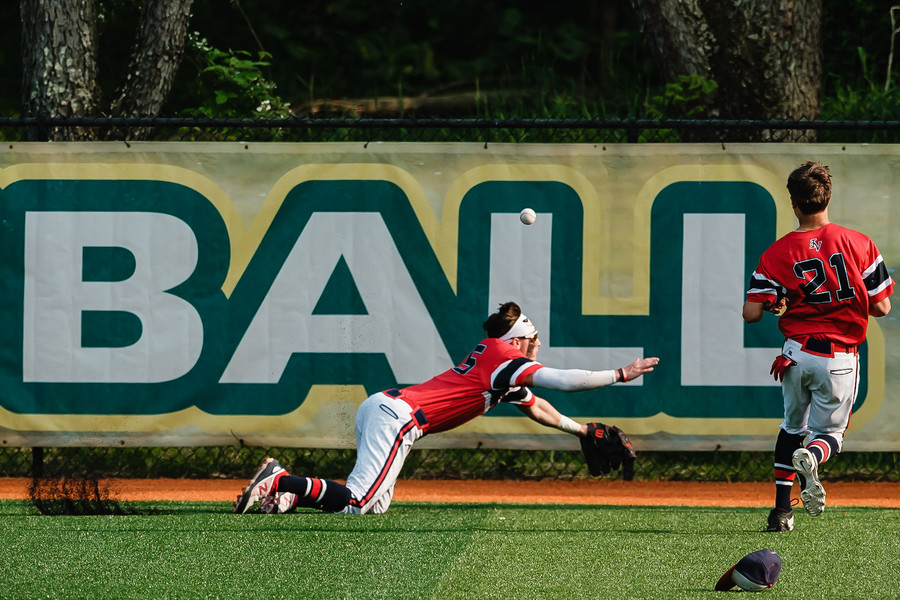 1st - Photographer of the Year - Small Market Indian Valley's Rafe Bonifay trips as he attempts to catch a bomb from Carrollton's Jaxon Rinkes that turned into an RBI triple during a Division II  district semifinal game, Monday, May 22 at Conotton Valley High School. (Andrew Dolph / The Times Reporter)