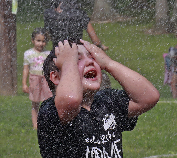Award of Excellence - Photographer of the Year - Small Market Tyler Armstrong, 7, cools off from the heat in the cool shower of water sprayed from a New Carlisle fire truck Friday, June 30, 2023, after playng in a mountain of bubbles during National Trail Parks and Recreation District's Foam Frenzy event at Smith Park. (Bill Lackey / Springfield News-Sun)