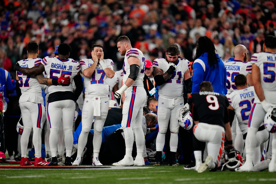 Sports Feature - Award of Excellence, “Damar Hamlin”The Buffalo Bills gather as an ambulance parks on the field while CPR is administered to Bills safety Damar Hamlin (3) after a play in the first quarter of a game against the Cincinnati Bengals at Paycor Stadium in Cincinnati on Monday, Jan. 2, 2023. The game was suspended after Hamlin was transported to University of Cincinnati Medical Center and players on both teams agreed not to retake the field. Officials initially called to resume play after a short break.  (Sam Greene / The Cincinnati Enquirer)