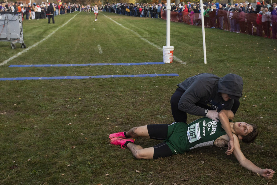 Award of Excellence - Ron Kuntz Sports Photographer of the Year Tinora’s Paul Westrick collapses after finishing the Division  III  final during the Northwest Regional High School Cross Country Championship at Hedges Boyer Park in Tiffin on Saturday, October 28, 2023.  (Rebecca Benson / The Blade)