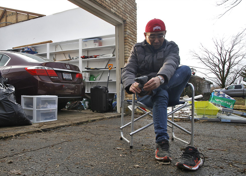 First Place, Photographer of the Year - Small Market - Bill Lackey / Springfield News-SunShoji Uota stops sorting through the remains of his house long enough to put on a pair of dry socks on Wednesday, Feb. 28, 2024. Uota's house on Ridge Road was destroyed by a F2 tornado a few hours earlier. 