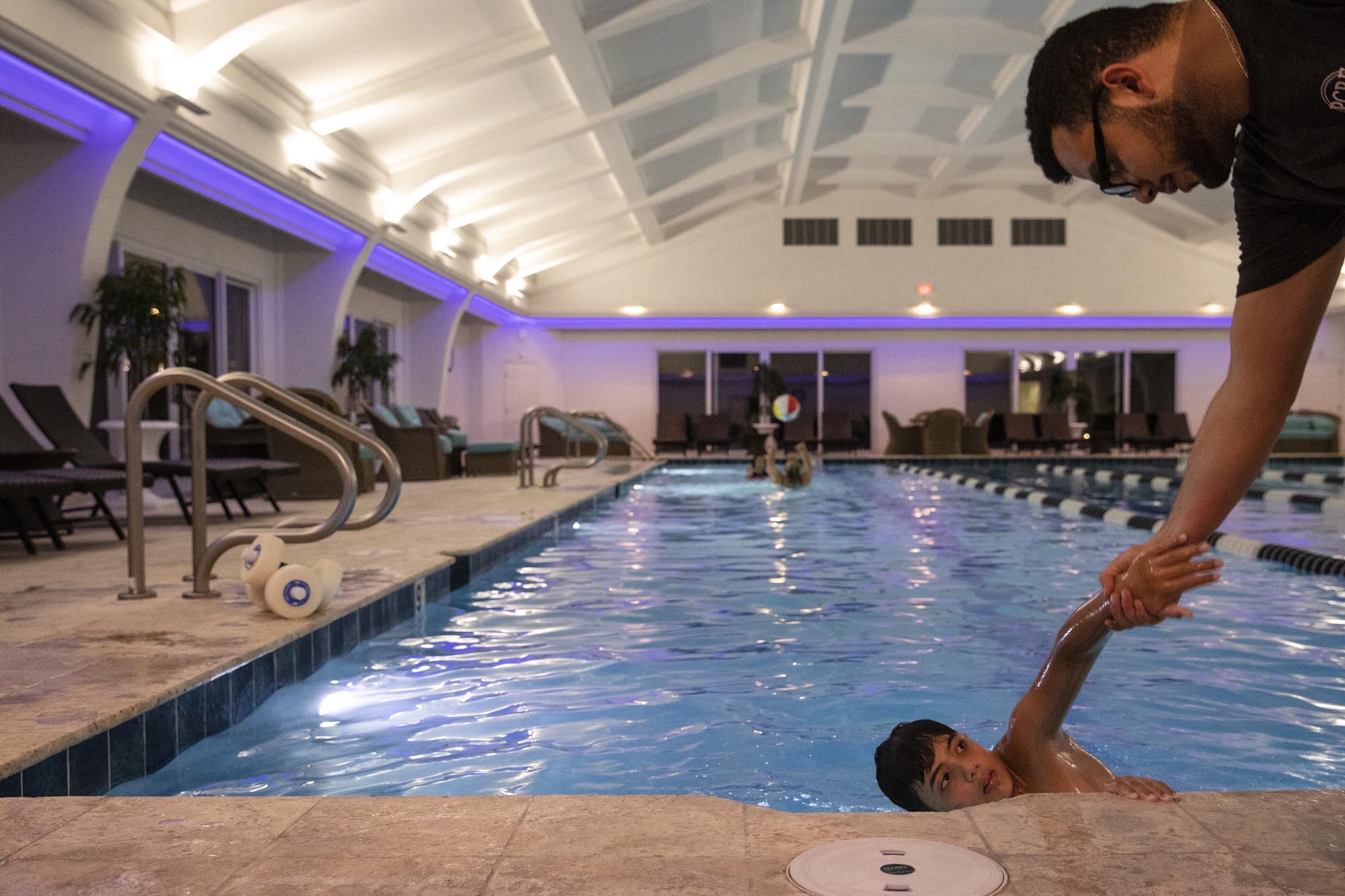 Yousef Mousa pulls Abood from the swimming pool. Abood did not want to leave, and had been refusing to get out of the water.
