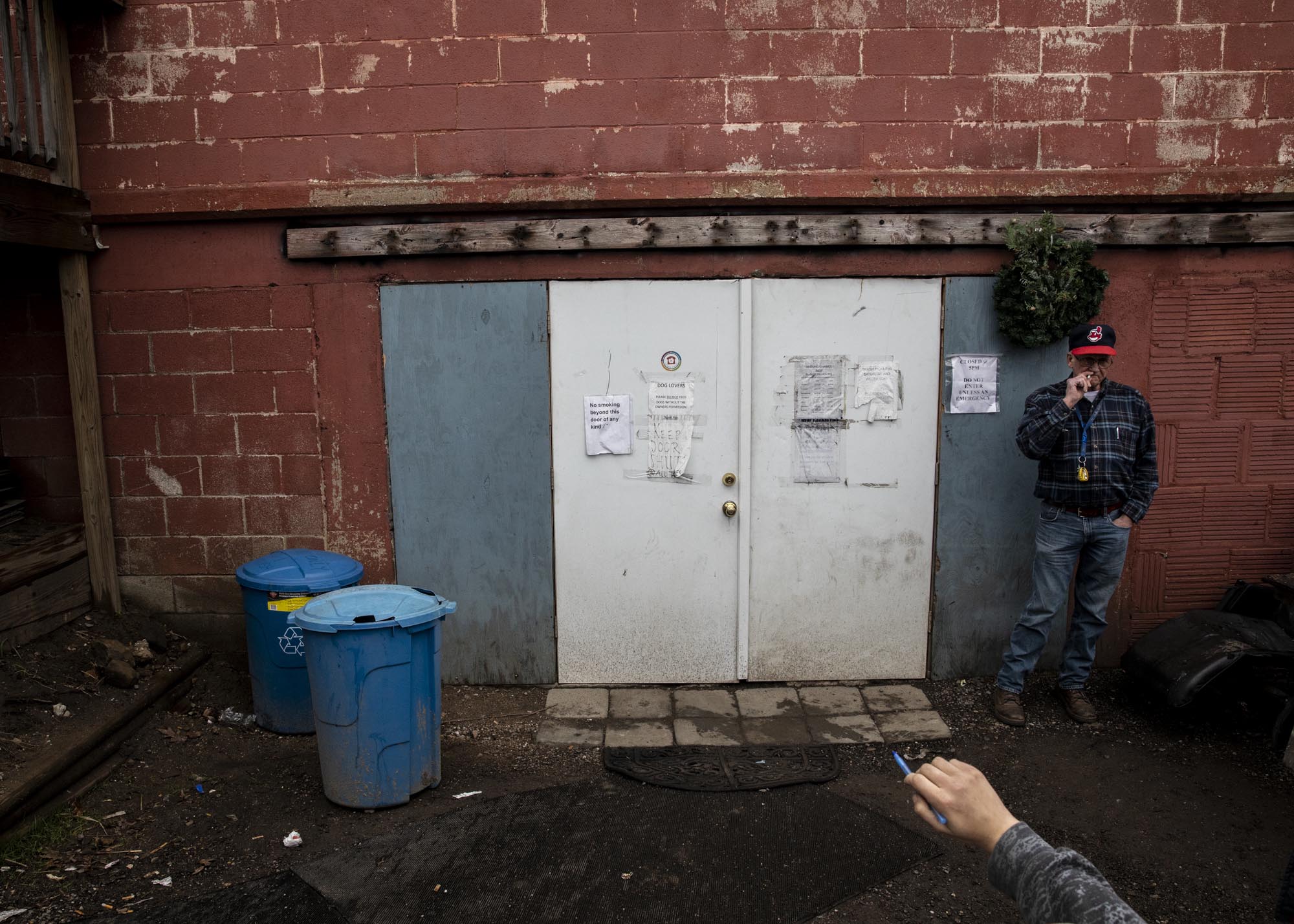 Herman smokes a cigarette outside the entry to Tent City. Residents and non-residents alike, most of whom are homeless, gather at Tent City during the day. Many smoke throughout the day, littering the ground with cigarette butts. "Most people ask why the homeless are always smoking, why they don't just quit and stop wasting their money. I always want them to think, how easy would it be for you to quit? It's not that easy," Herman said. A retiree, Herman lived at Tent CIty for months before finding an apartment he could afford. He now volunteers at Tent City.