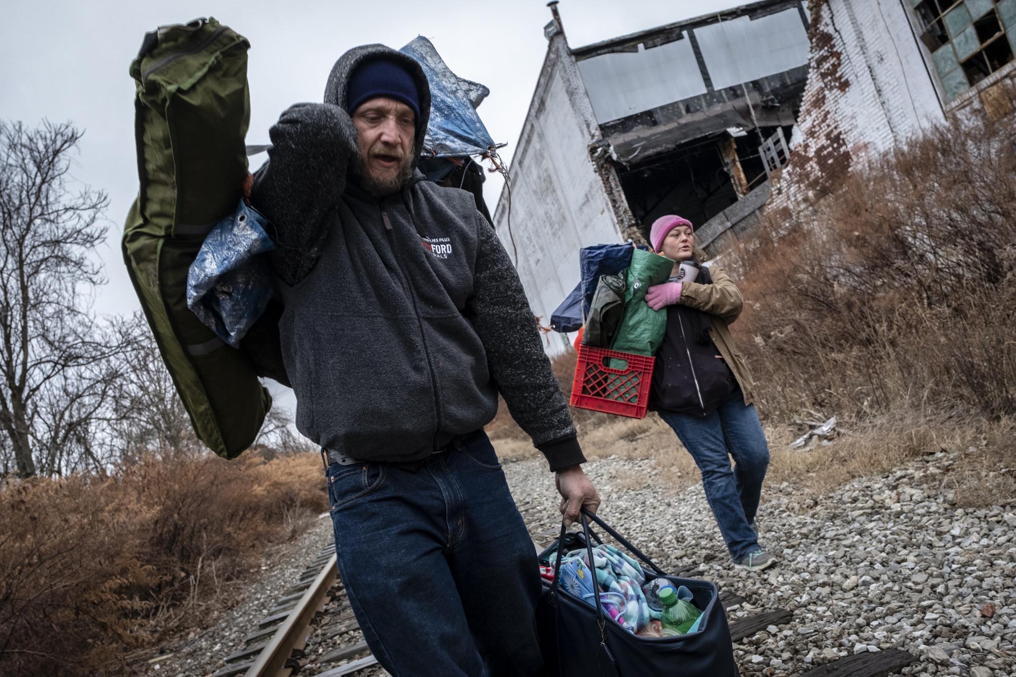 Carrying their belongings, Krystal Emch and Michael Smith leave Tent City. The City of Akron issued an eviction notice on Dec. 6, 2018, giving the residents 30 days to leave. After City Council voted to close Tent City, a push was made to house the residents. However, not everyone was housed, and those who were not living at Tent City when the vote was taken were not given the opportunity to receive housing. Krystal and Michael were not on the original list, and thus were forced to move back into the woods.